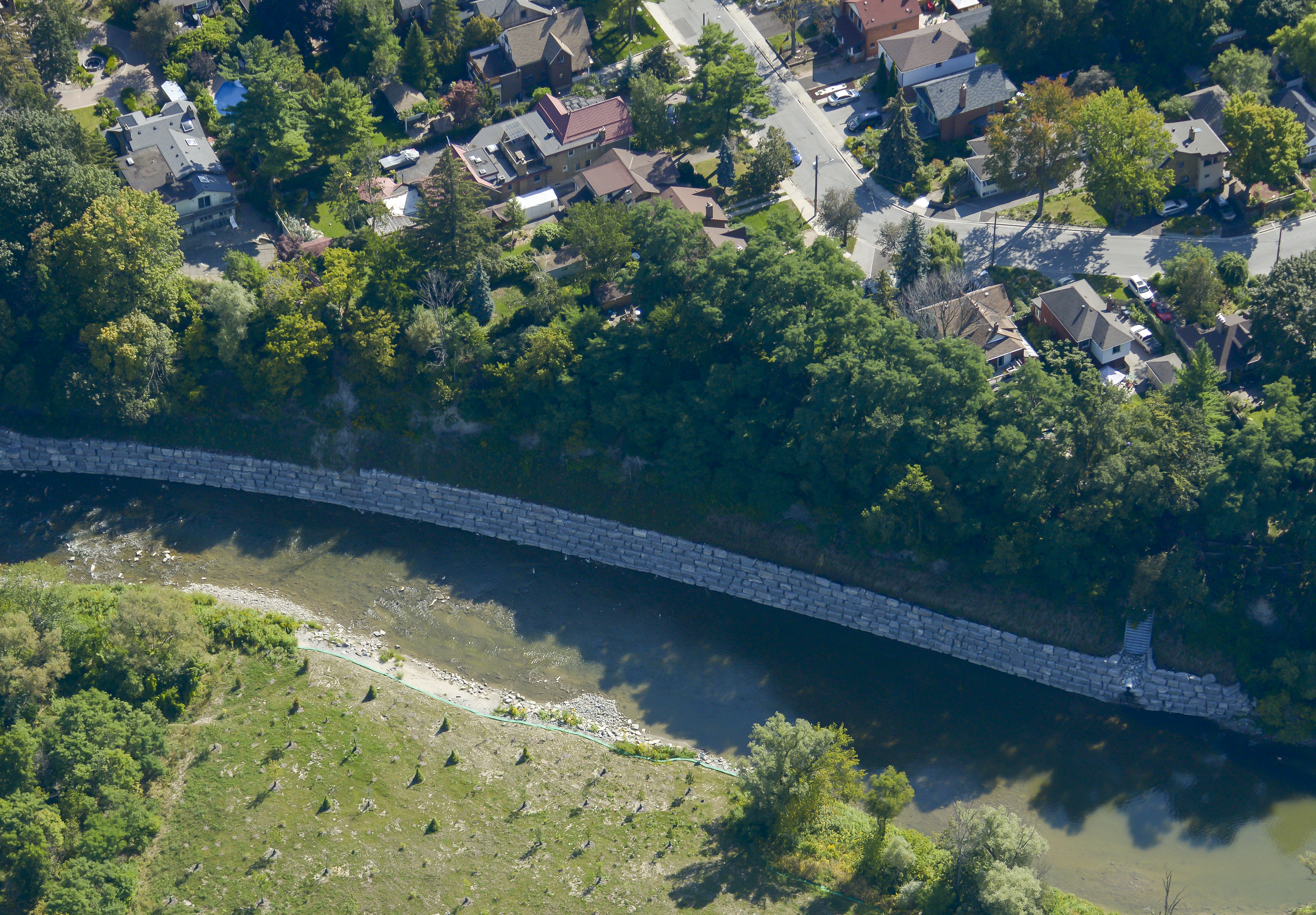 An aerial view of an armourstone wall along the bank of the Humber River